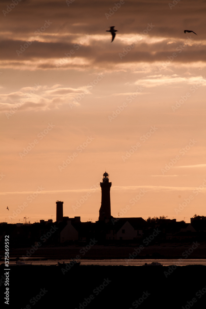 silhouette of a lighthouse at sunset
