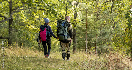 A young girl and her boyfriend are walking in the forest, enjoying nature.