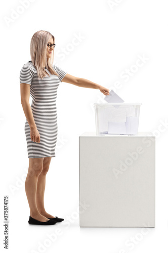 Full length shot of a young woman voting in a plastic box photo