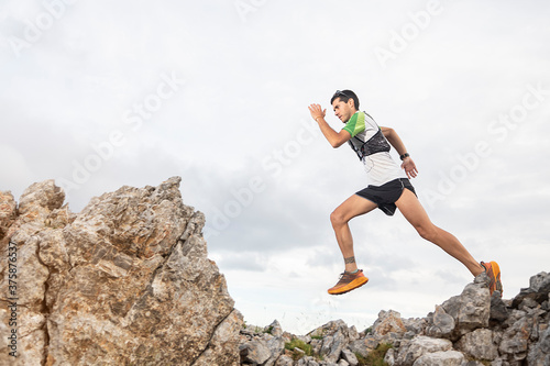 Athlete Runner Runs Rocks In Mountain