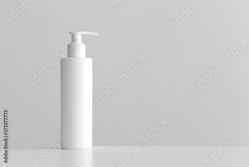 White cosmetic shampoo dispenser bottle mockup with blank copy space on a white table.