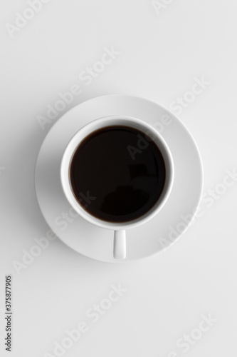 Top view of a cup of coffee on a white table.