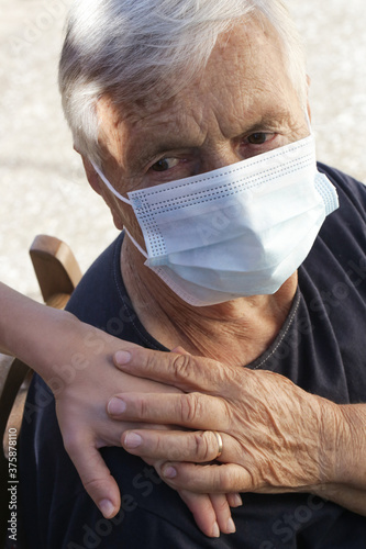 Portrait of elderly caucasian woman wearing protective medical mask. Care for the elderly people during corona virus outbreak, helping hand, home care concept. 