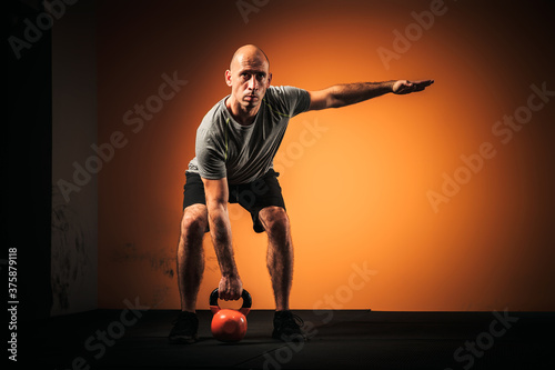 Male athlete deadlift kettlebell in the gym. 
