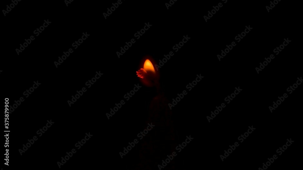 A match lights a fire on wax candle in dark A match lights a fire on wax candle in dark