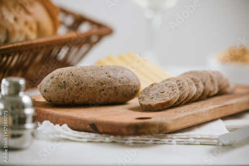 Queso de cerdo codeguín en tabla de madera con quesos y pan, acompañado de vino blanco