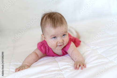 Caucasian baby girl as he lays on bed