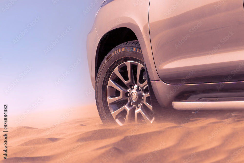 Close up of a golden car stuck in the sand in the Namib desert.