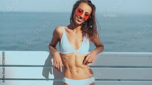 slow motion profile view Pretty woman in whihte bikini having fun beach vacation resort. tanned girl enjoying seascape view sunny day summer vacation photo