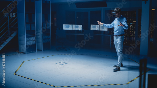 In 3D Content Creating Laboratory Engineer Wearing Professional Virtual Reality Headset Works and Gestures in Augmented Reality. Industrial Software Design Facility
