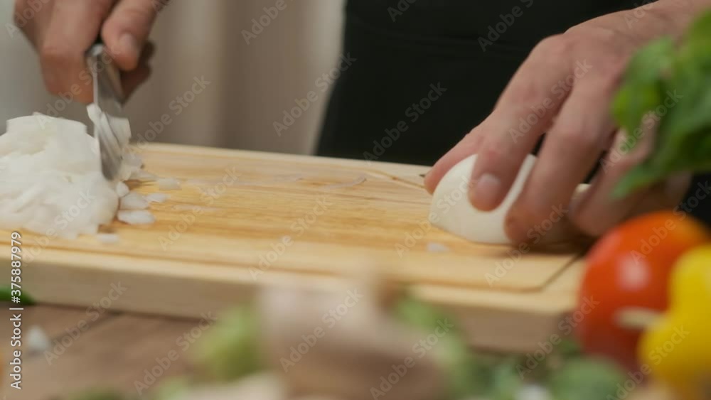 Professional chef prepares and cuts white onion. Close up slow motion Professional chef prepares and cuts white onion. Close up slow motion