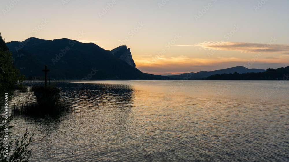 Kreuzstein am Mondsee mit Drachenwand bei Sonnenuntergang