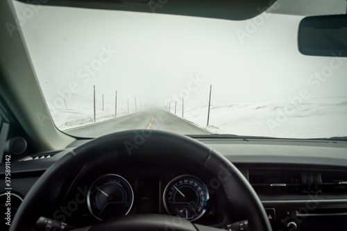 Bilde på lerret Car interior point of view on road cleared from snow and ice, but piled up on the side of the road