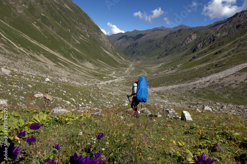 Backpackers trekking in mountains. A tourist with a backpack descends into a mountain valley. Caucasus.