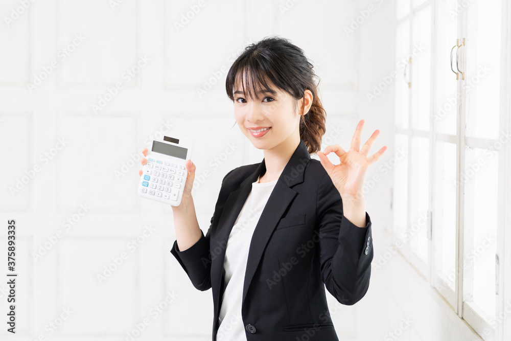 電卓を使う若いビジネスウーマン