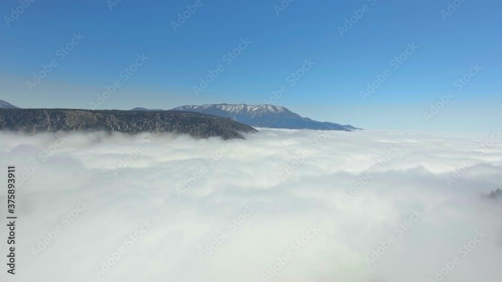 Bird's-eye drone view over a thick layer of clouds that enveloped the earth in California, USA