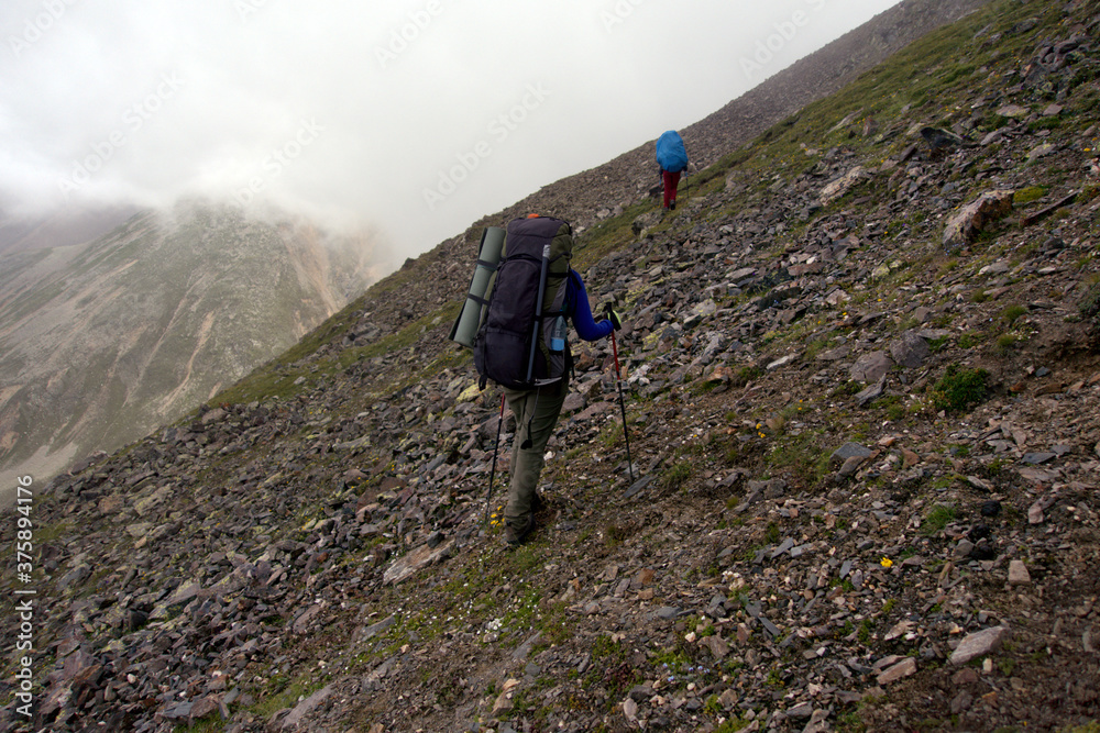 Mountain tourism. Tourists climb the mountain pass. Tourists climb the Shirman North Pass (3450 meters above sea level).