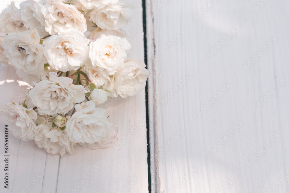 sprig of white small roses on white wooden background. Happy Birthday. Wedding invitation.