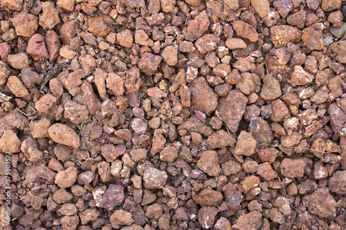 Background texture of a road or sidewalk made of red gravel stone.
