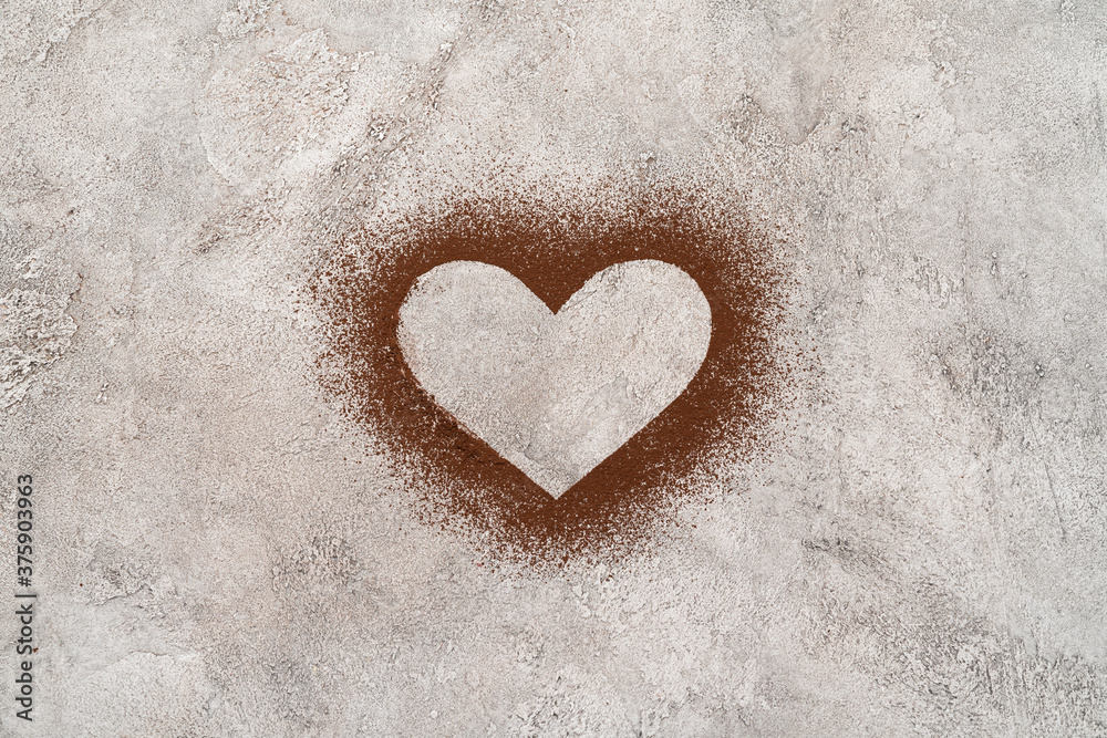 Heart shape of spreading cocoa powder onc oncrete background