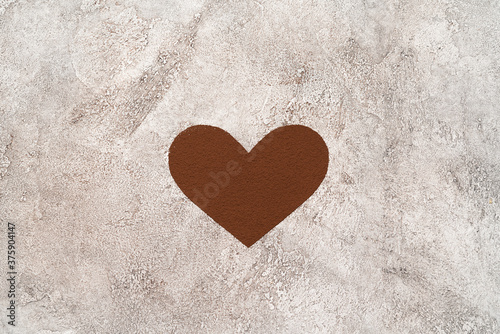 Heart shape of spreading cocoa powder onc oncrete background