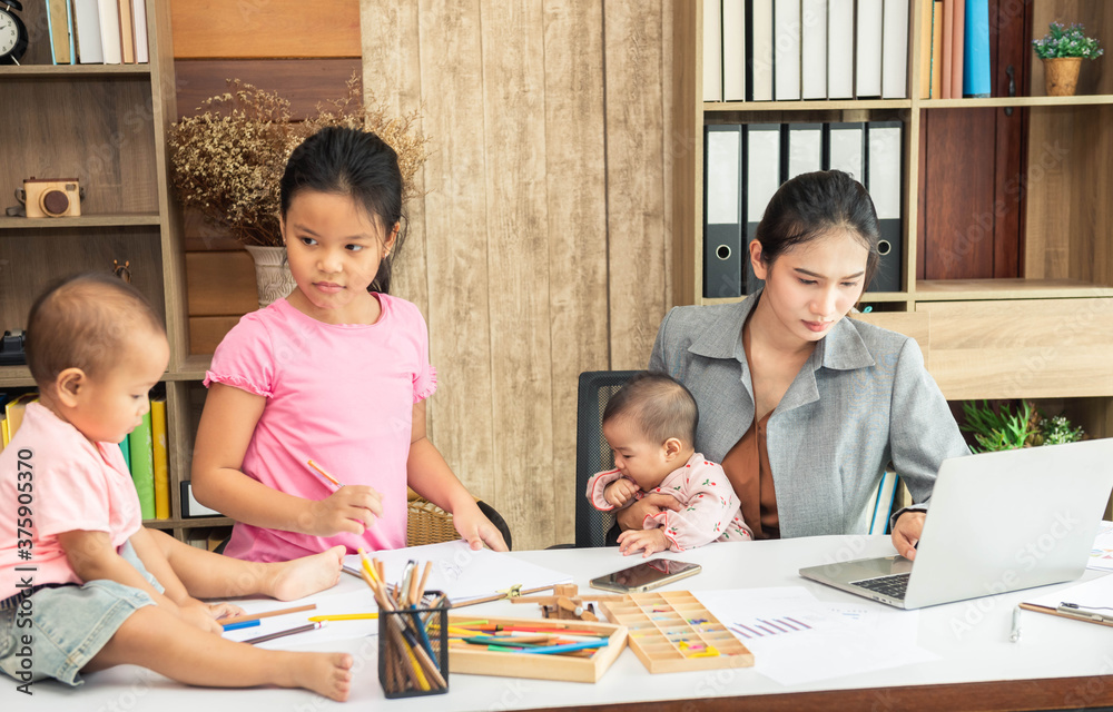 Busy asian woman trying to work while baby sitting three kids. Asia single mom work from home with the children. Busy asian woman trying to work while baby sitting three kids. Asia single mom work from home with the children.