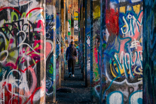 A Man In-Between A Row of Graffiti Covered Walls at Graffiti Pier © HRTNT Media