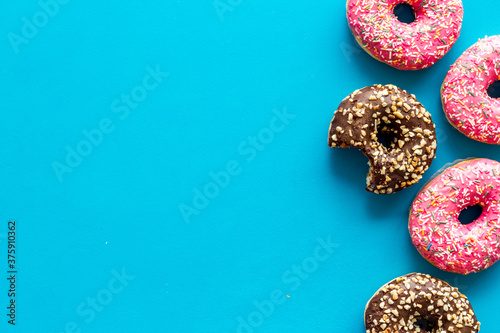 Donuts flat lay pattern on blue background, top view