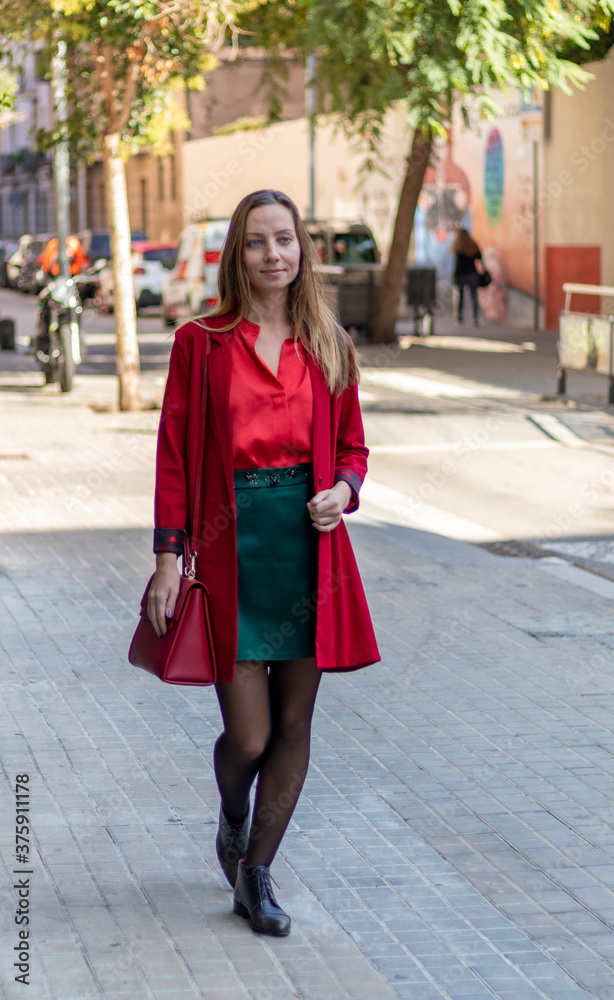 Blonde girl in a red shirt walking down the street