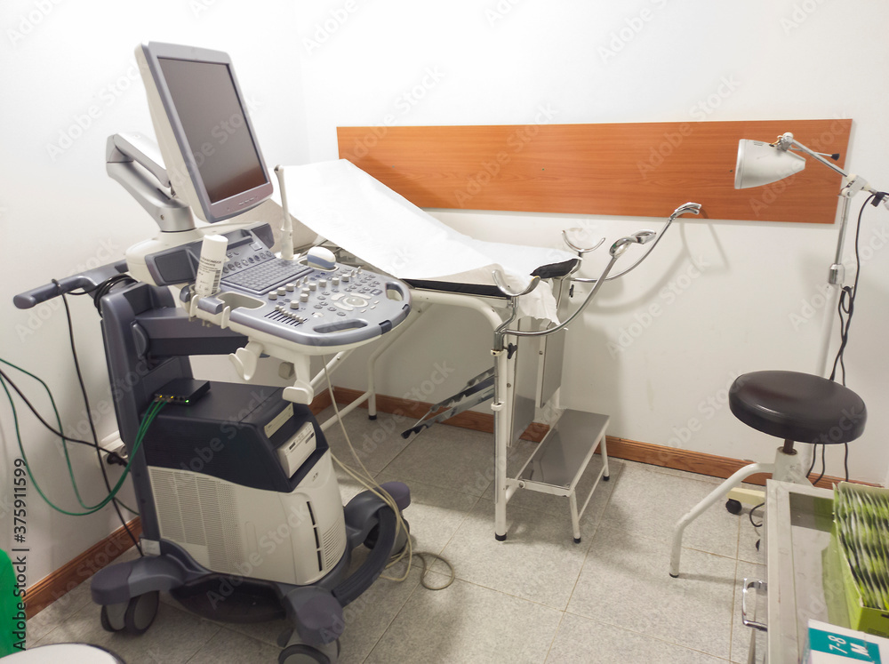 gynecology room with ultrasound machine and stretcher.