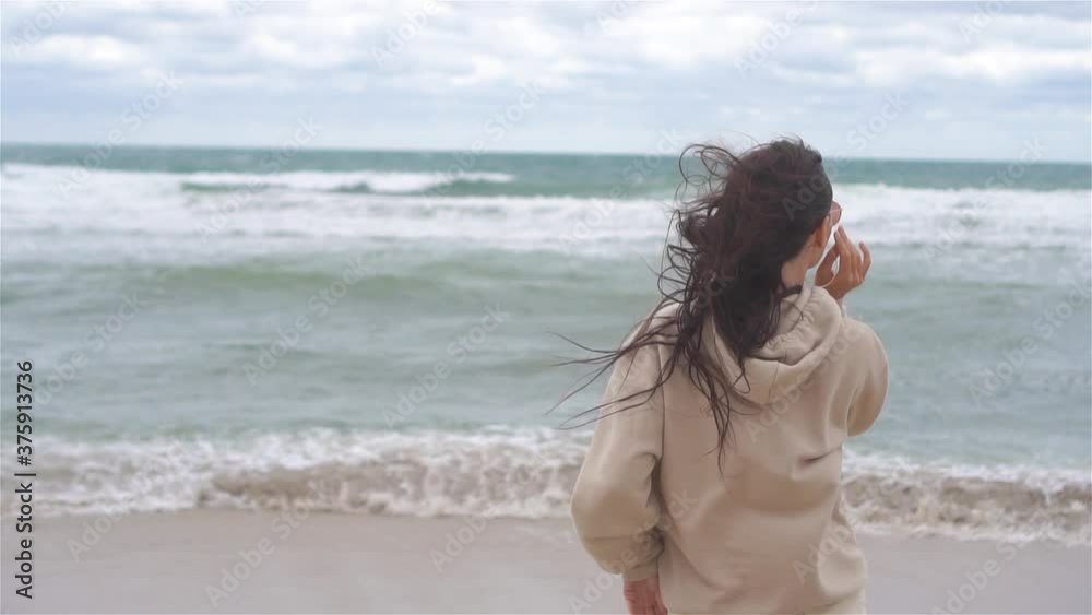 Young woman on the beach in the storm Young woman on the beach in the storm