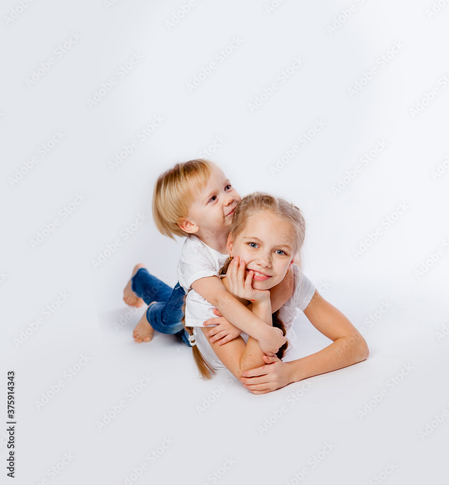 cute brother and sister in blue jeans and t-shirts hugging cute brother and sister in blue jeans and t-shirts hugging