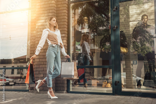 Close up portrait of attractive lady hold many bags shopper woman wear white shirt jeans heels girl carrying new clothes packs things shopping buyings retail store sales black friday concept © Volodymyr