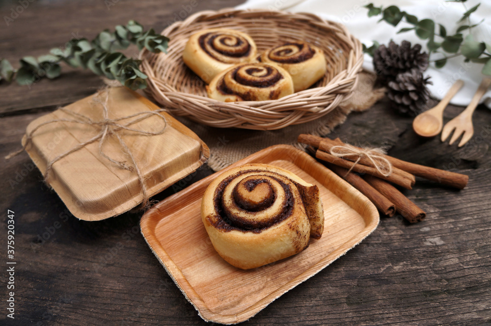 Homemade Cinnamon rolls on a plate from nature on a wooden table.