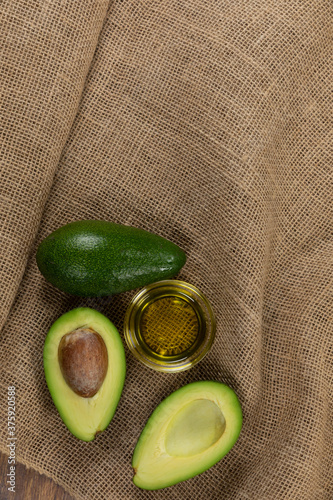 View of two avocados and olive oil bottle on cloth background