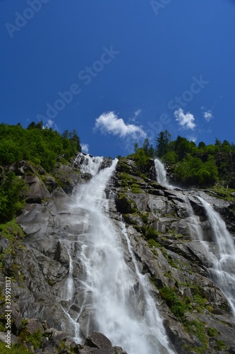 waterfall in the mountains with trees and blue sky no people copy space