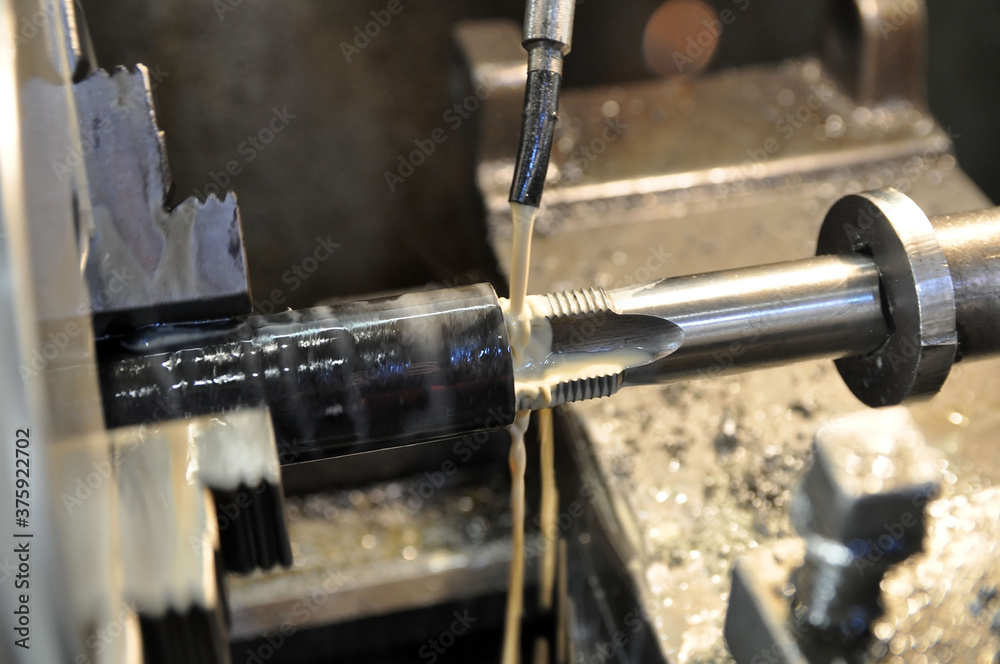 Metalworking machine at work. Lubricating and cooling fluid Metalworking machine at work. Lubricating and cooling fluid