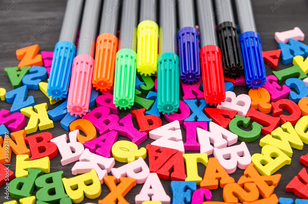 Naklejka premium Colored markers and letters. School concept background. Time to go to school.