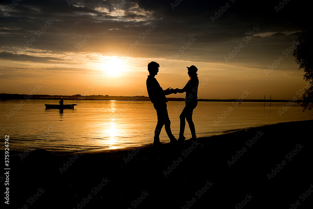 silhouette of a couple on the beach, holding hands