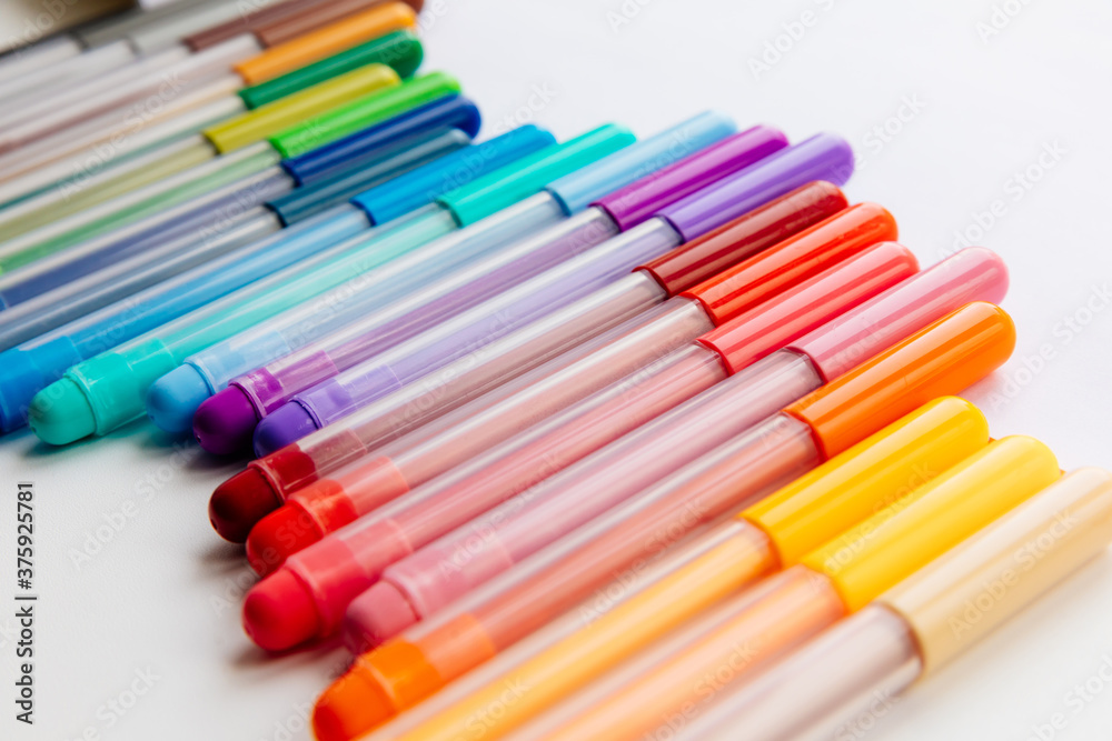 multi-colored markers on a white background