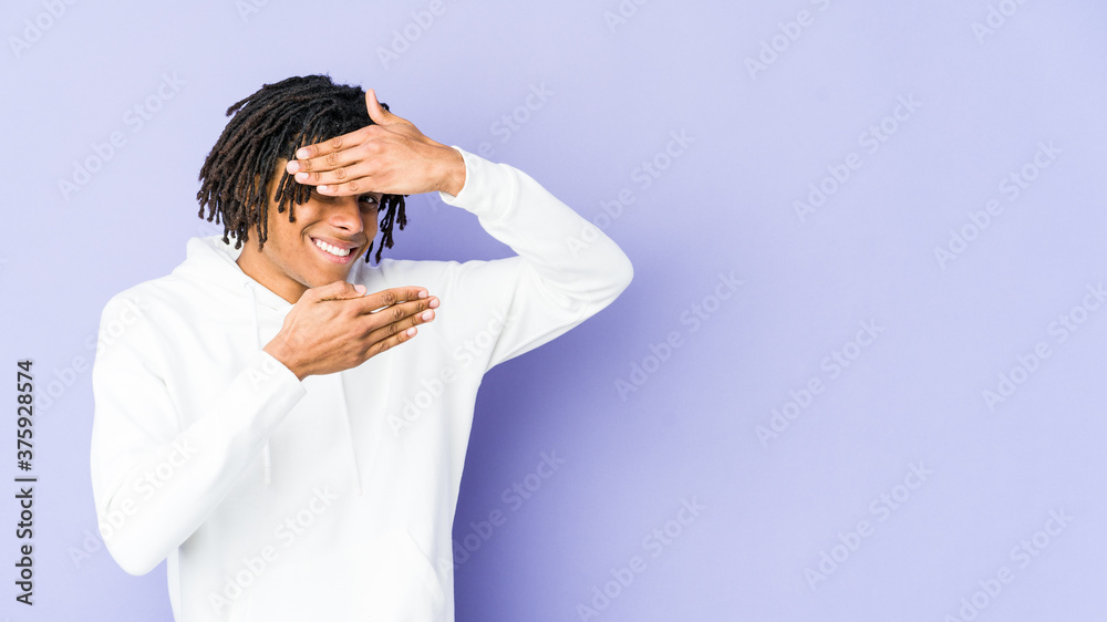 Young african american rasta man blink at the camera through fingers, embarrassed covering face. Young african american rasta man blink at the camera through fingers, embarrassed covering face.