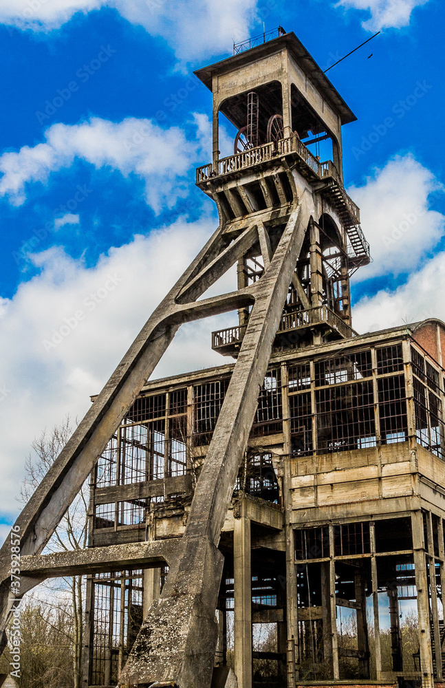Towers of an old mine under renovation, sunny day with a blue sky with white clouds Maasmechelen, Belgium Towers of an old mine under renovation, sunny day with a blue sky with white clouds Maasmechelen, Belgium
