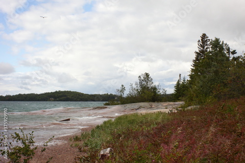 sandy beach in the afternoon light and wavy water
