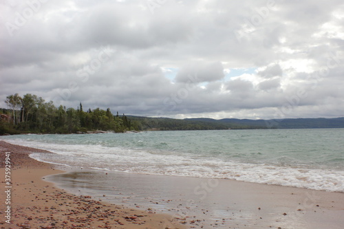 sandy beach in the afternoon light and wavy water