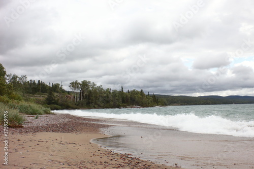 sandy beach in the afternoon light and wavy water