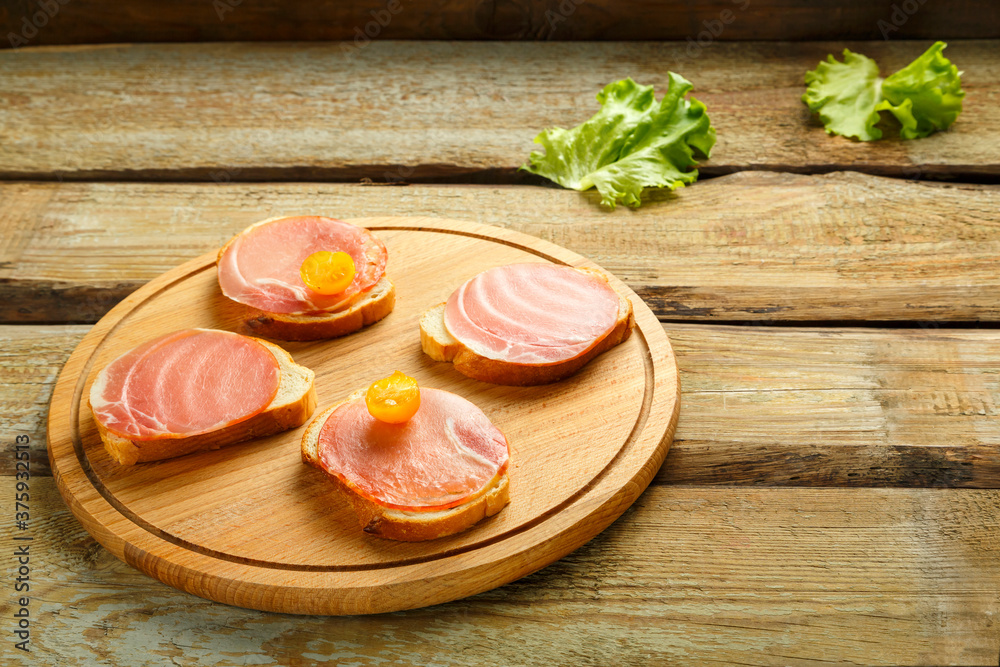 Sandwiches with ham and cherry on a wooden board. Copy the place Sandwiches with ham and cherry on a wooden board. Copy the place
