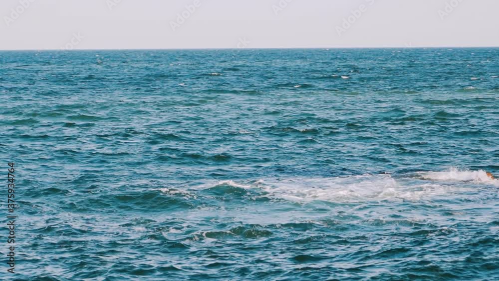 Waves swaying on the sea water. Amazing water background at storm. Beautiful blue water of the ocean with waves and white foam. Slow motion. Waves swaying on the sea water. Amazing water background at storm. Beautiful blue water of the ocean with waves and white foam. Slow motion.