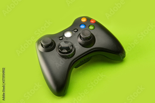 Video game control on a platform with green background, selective focus.