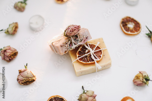 natural homemade soap bars and flowers on white background. Spa concept, body care products. Holiday gift, top view flat lay  © paralisart