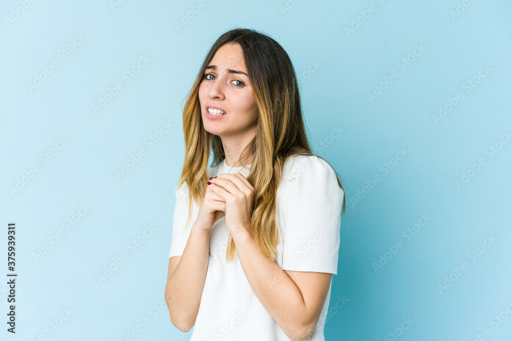 Young caucasian woman isolated on blue background scared and afraid. Young caucasian woman isolated on blue background scared and afraid.